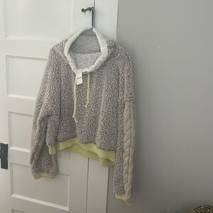 faux furry/sherpa slip on top. cream knitted sleeve. Draw string at neck.